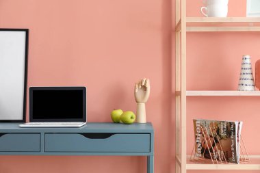 Renk duvarının yanında modern tablo ve kitaplık