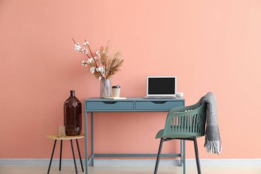 Renk duvarının yanında ekoseli modern işyeri ve sandalye