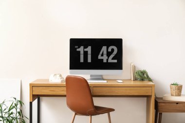 Işık duvarının yanında bilgisayar olan ahşap işyeri