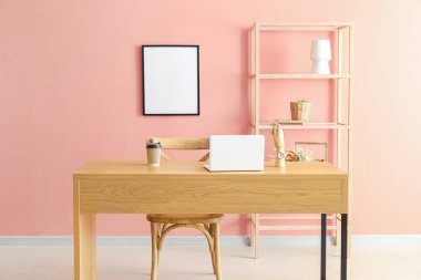 Çalışma yeri ve renk duvarına yakın kitaplığı olan modern odanın içi