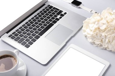 Dizüstü bilgisayarlı tablet bilgisayar ve arka planda çiçek