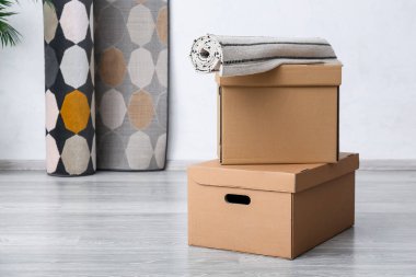 Odada rulo halı olan karton kutular.