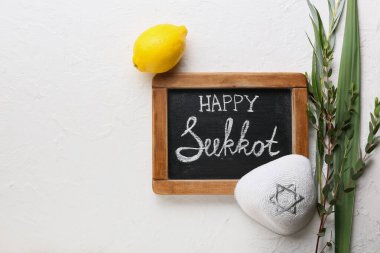 Işık arkaplanda Mutlu SUKKKOT ve festival sembolleri yazılı tebeşir tahtası