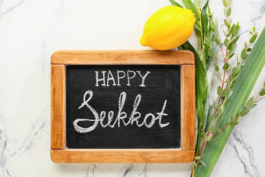 Işık arkaplanda Mutlu SUKKKOT ve festival sembolleri yazılı tebeşir tahtası