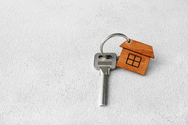 Işık arka planında anahtarlığı olan evden anahtar