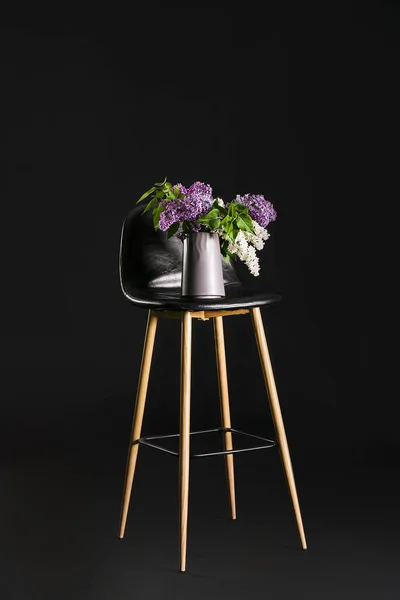 暗い背景にスタイリッシュな花瓶やライラックの花と椅子 — ストック写真