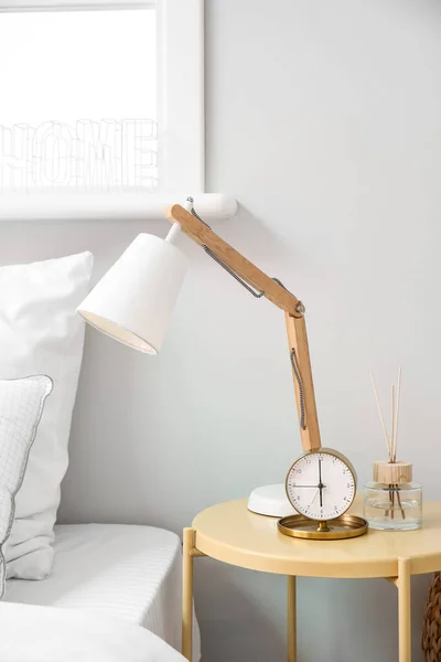 Holzlampe Und Wecker Auf Dem Tisch Neben Bequemem Bett Schlafzimmer — Stockfoto