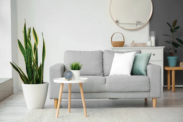 Bequemes Sofa Und Tisch Mit Wecker Der Nähe Der Lichtwand — Stockfoto