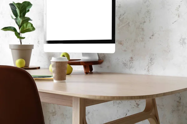 ライトウォールの近くに茶色の椅子とコンピュータ付きのテーブル — ストック写真