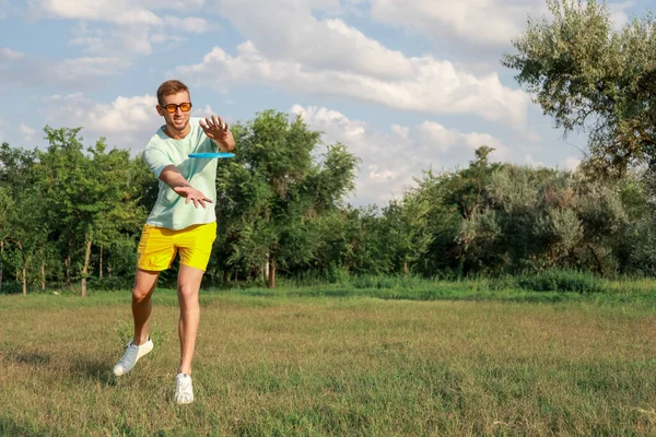 Frizbi parkta oynayan genç adam