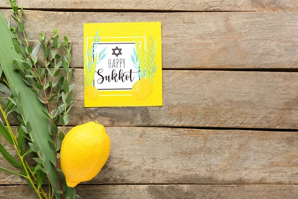 Tahta arka planda Sukkot festival sembolleri ve tebrik kartı