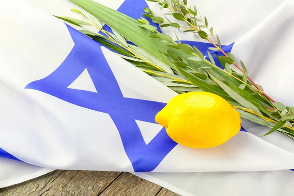 Tahta arka planda Sukkot festival sembolleri ve İsrail bayrağı