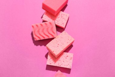 Renk arkaplanında pembe temizlik süngerleri