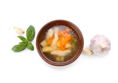 Beyaz arka planda bir kase lezzetli hamur çorbası ve sarımsak.