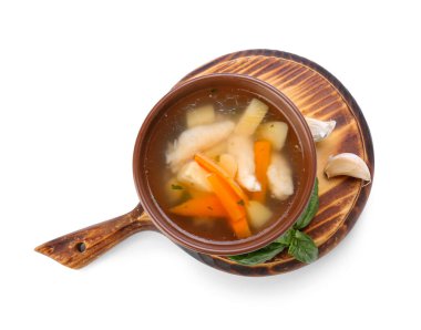 Tahta tahtada beyaz arka planda bir kase lezzetli hamur çorbası var.