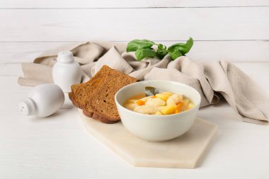 Lezzetli hamur çorbası ve hafif ahşap zemin üzerinde ekmek ile kase