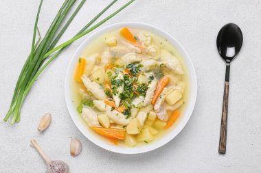 Bir kase lezzetli köfte çorbası, yeşil soğan ve hafif arkaplanda sarımsak.