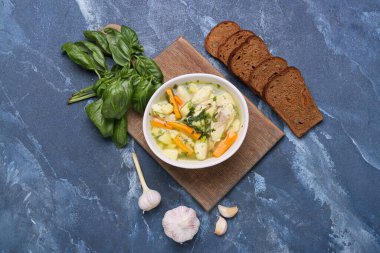 Renkli arkaplanda bir kase lezzetli hamur çorbası ve malzemeyle kompozisyon