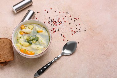 Renkli arkaplanda bir kase lezzetli hamur çorbası, ekmek ve baharatlı kompozisyon