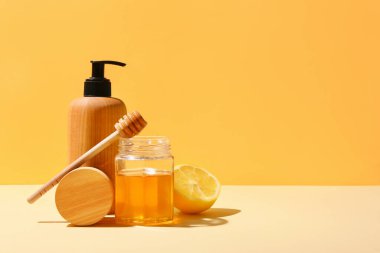 Kozmetik ürünleri ile kompozisyon, bal ve limon renk arkaplanı