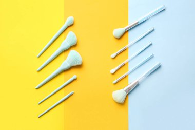 Renkli arkaplanda şık makyaj fırçaları olan kompozisyon