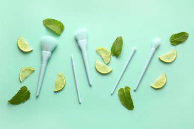 Renkli arkaplanda naneli ve limonlu makyaj fırçaları