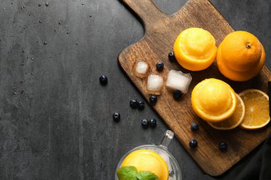 Koyu arkaplanda portakal kabuklu lezzetli dondurmalar olan tahta.