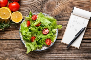 Tahta arka planda taze salata ve yemek planı.