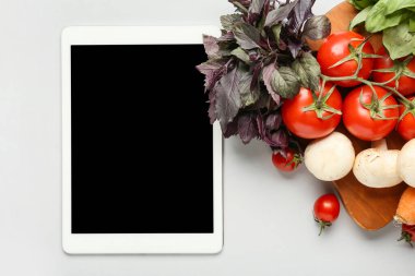 Beyaz arka planda sağlıklı ürünleri olan tablet bilgisayar