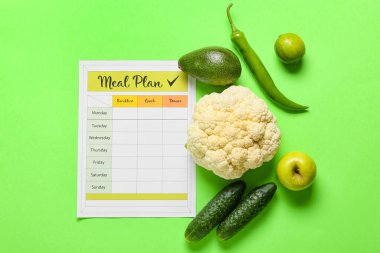 Yeşil zemin üzerinde yemek planı olan sağlıklı ürünler