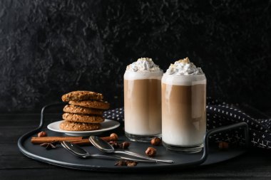 Siyah arka planda fındıklı ve kurabiyeli latte.
