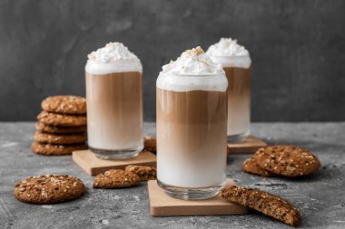 Bir bardak lezzetli latte ve arka planda fındıklar.