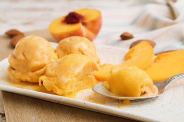 Masada lezzetli şeftalili dondurma tabağı, yakın plan.