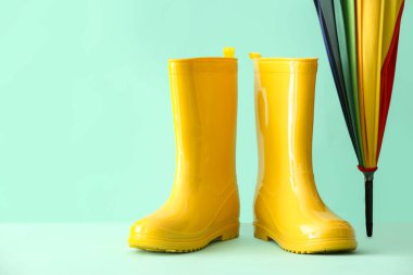 Renkli arka planda lastik çizmeler ve şemsiye, yakın plan