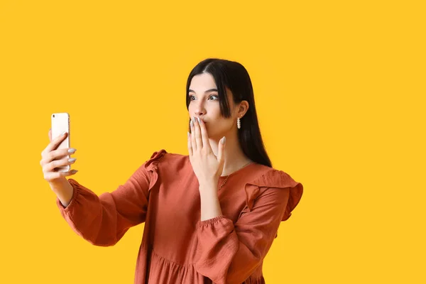 Überraschte Junge Frau Mit Handy Macht Selfie Auf Gelbem Hintergrund — Stockfoto
