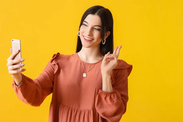 Pretty Young Woman Taking Selfie Showing Victory Gesture Yellow Background — Stock Photo, Image