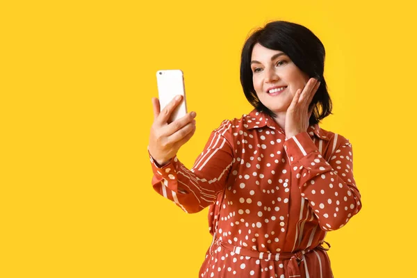 Mature Woman Mobile Phone Taking Selfie Yellow Background — Stock Photo, Image