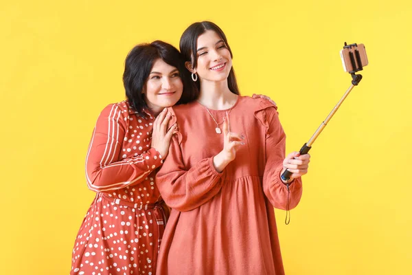 Mature Woman Her Young Daughter Taking Selfie Yellow Background — Stock Photo, Image