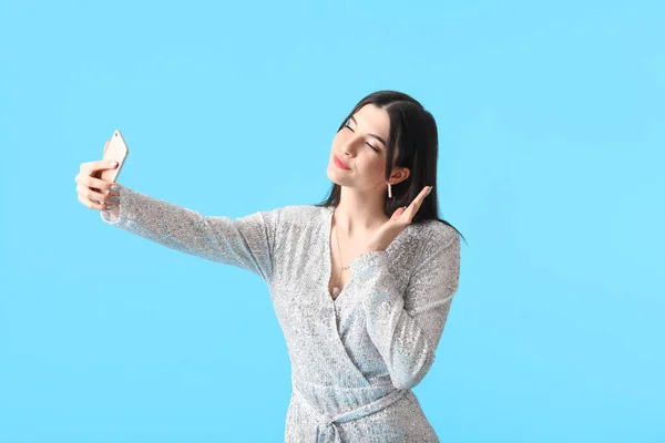 Hübsche Junge Frau Mit Handy Macht Selfie Auf Blauem Hintergrund — Stockfoto