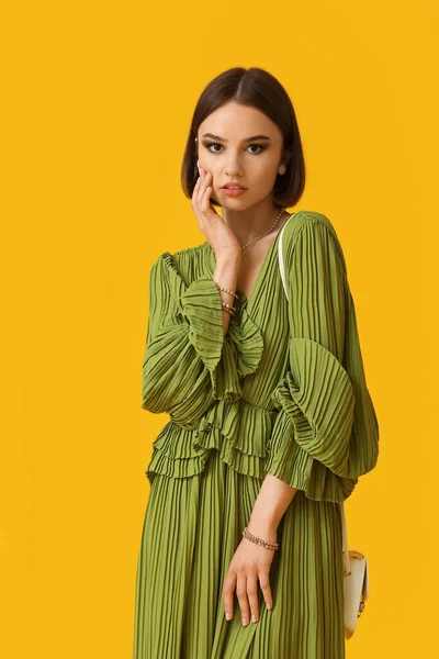 Moda aksesuarları olan kadın renk arkaplanına dokunuyor