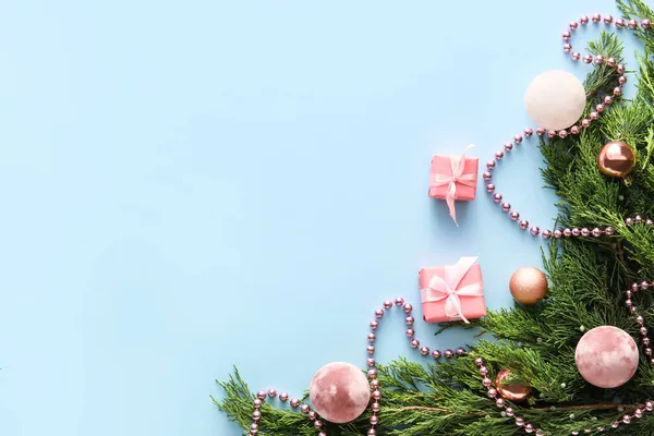 Mavi arka planda kozalaklı dalları ve Noel süslemeleri olan kompozisyon, yakın plan