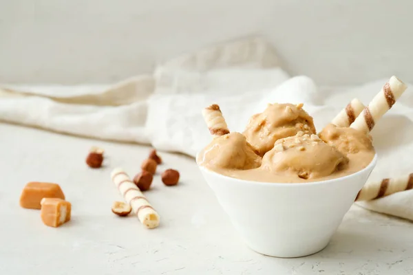 Schüssel Mit Leckerem Karamelleis Mit Nüssen Auf Weißem Hintergrund — Stockfoto