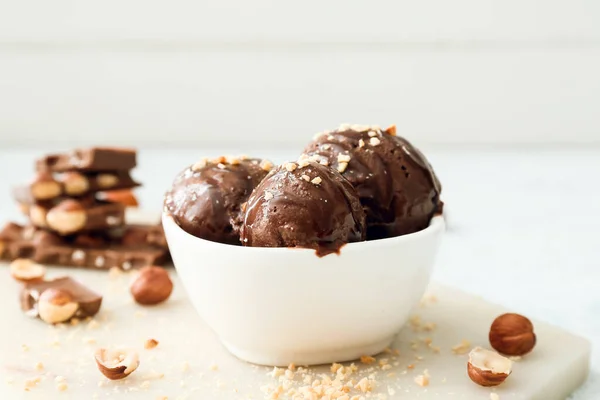テーブルの上にナッツとおいしいチョコレートアイスクリームのボウル — ストック写真