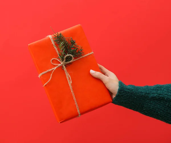 Vrouwelijke Hand Met Geschenkdoos Rode Achtergrond Close — Stockfoto