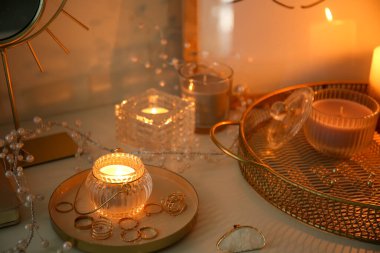 Karanlık odadaki mücevherlerle parlayan aroma mumları.