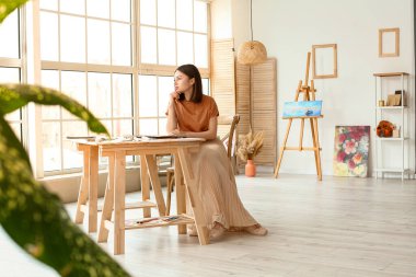 Atölyede çizim yapan genç bir kadın sanatçı