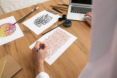 Ofiste çalışan erkek Arap el yazısı sanatçısı.