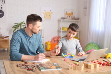 Ofiste küçük bir çocukla çalışan erkek psikolog. Otizm kavramı