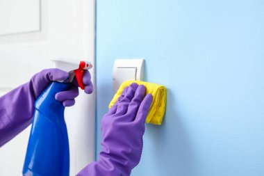 Mavi duvardaki kadın temizleme düğmesi, yakın plan.