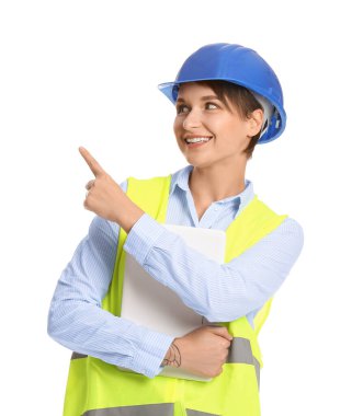 Bilgisayarlı kadın inşaat işçisi beyaz arka plandaki bir şeyi işaret ediyor.